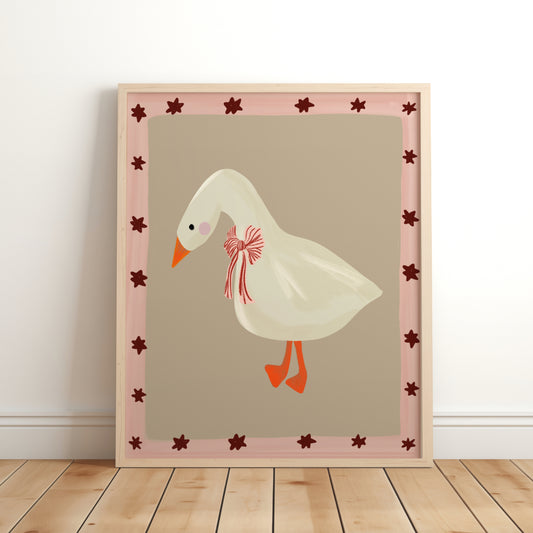 Illustrated goose with a red striped bow around its neck, set against a neutral beige background with a pink and burgundy star border – framed nursery wall art