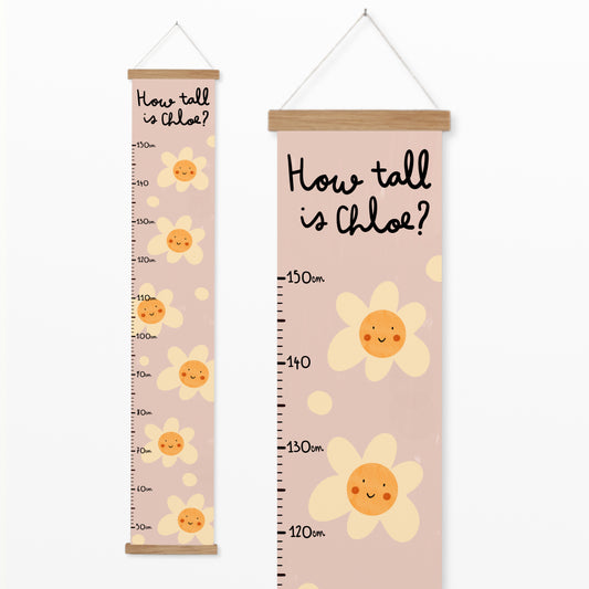 Pink personalised canvas height chart with smiling daisy flowers and "How tall is Chloe?" text, designed to measure child growth from 50 cm to 150 cm.