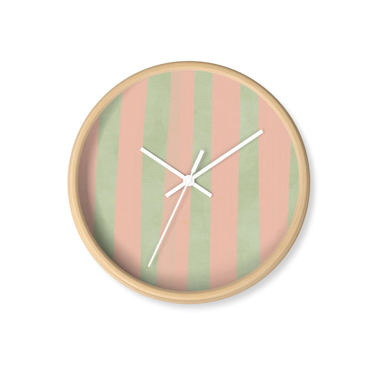 Round bamboo nursery wall clock with hand-painted green and pink watercolour stripes and white clock hands on a soft background